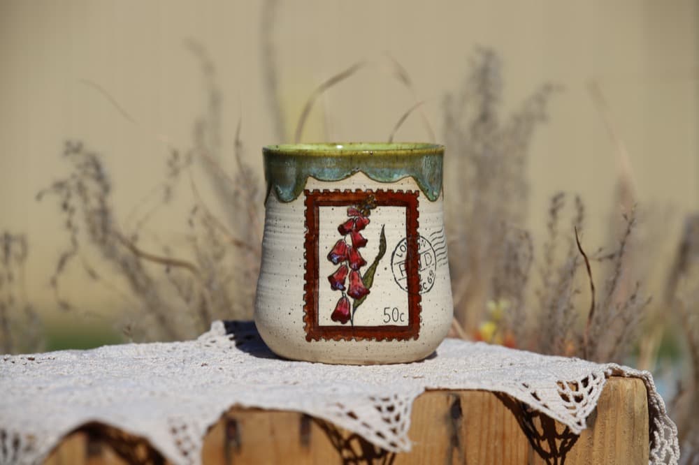 Speckled mug with a red foxglove postage-stamp design, inspired by a family trip to Scotland