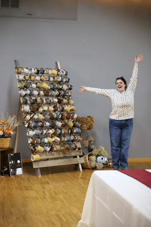 Abby celebrating next to the finished mug wall