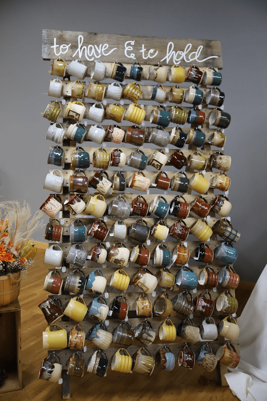 The full wedding mug wall holding over a hundred handmade mugs